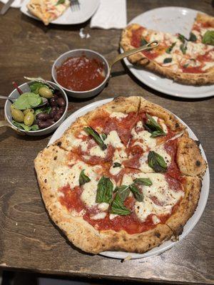 Margherita pizza with pepperoni, A plate of olives appetizer