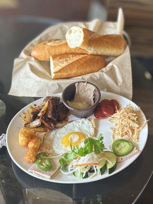 Combos Plate: sunny side egg, shaking beef, Chinese sausage, shredded chicken, pork loaf, tater tots, veggies, aioli, pâté & baguette | $15