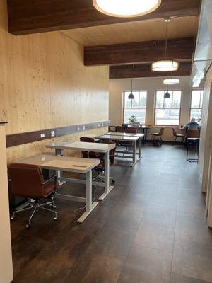 Top floor standing desks and wood tables in background