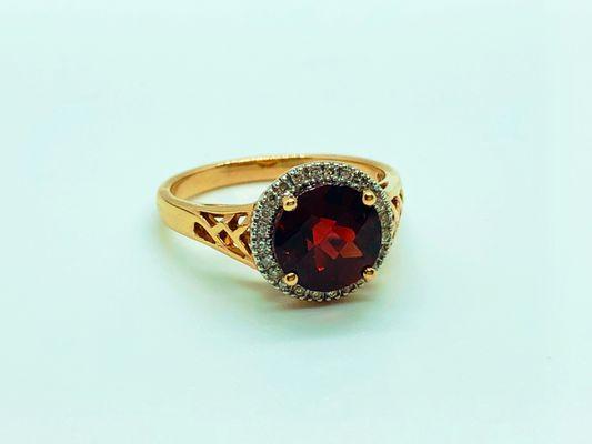 14 karat yellow gold ring with round garnet center and diamond halo