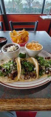 Carne Asada tacos with rice and beans.