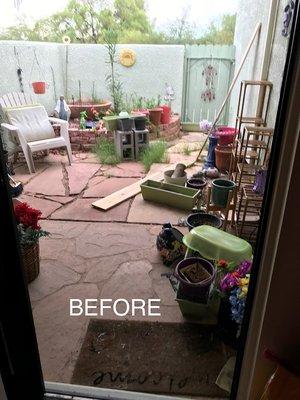 The patio BEFORE we had Action Yard and Tree come beautify it.  Lots of gardening junk accumulated, and many dead and overgrown plants.