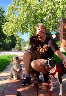 Harper Page, co-owner of Pet Pals KC, know she has the best job in the world! Here she gets puppy kisses from Gus, Hazel, and Coco.