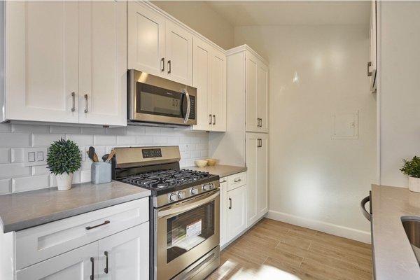 Subway tile backsplash, design of cabinet layout, spice drawer, mystery grey quartz countertop, molding and handles