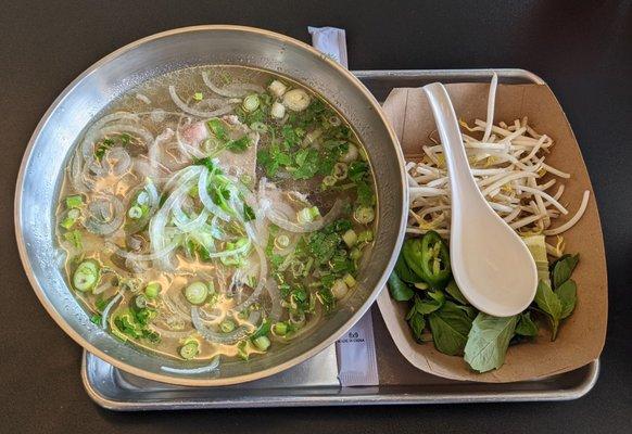 Beef pho with bean sprouts, mint, lime wedge, and sliced hot peppers