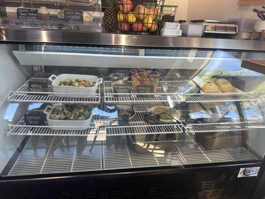 Deli case with fresh made entrees, salads, and sides.