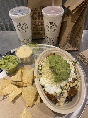 Plant-based chorizo rice and bean bowl with salsa cheese sour cream and guacamole