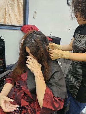 This is the beginning. Shin is looking at the texture of her hair and seeing how much product she needs to make.They put a robe on you, too.