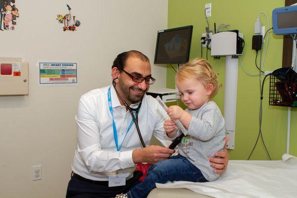 Dr. Alkayed's all smiles doing what he does best: helping his pediatric patients.