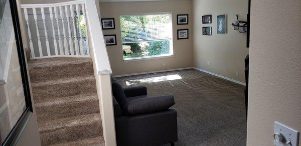 Larger room with stairs after being cleaned.