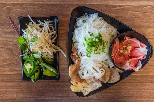 The fresh bean sprouts and herbs complement the pho perfectly--vibrant, crisp, and ready to mix!