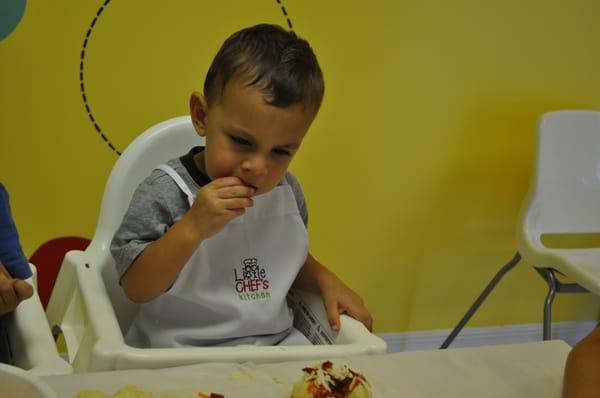 a 20-month old exploring his pizza ingredients