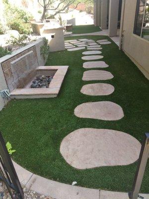 Synthetic turf with step stones between the turf with flagstone patio too