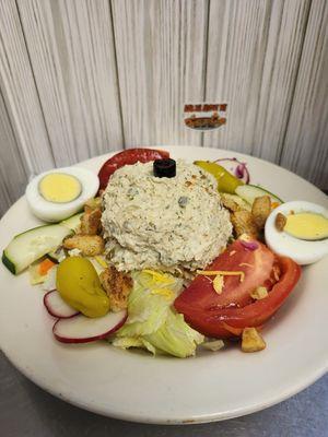 Garden salad topped with chicken salad