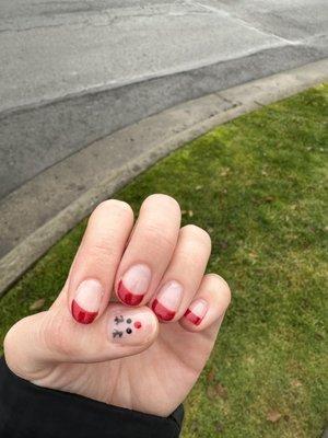 Sparkly red French tips and a reindeer accent nail