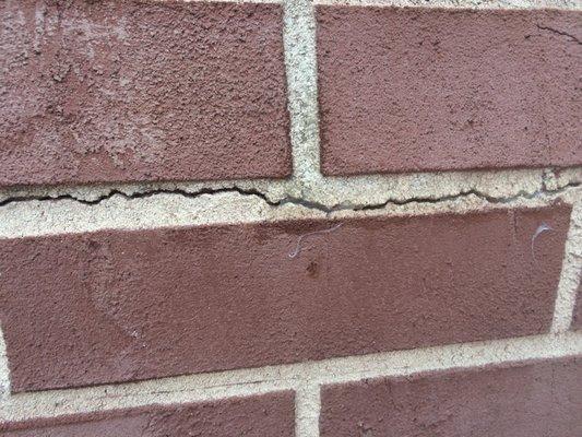 Shoddy crack-sealing job, with silicone-acrylic caulk drips dried all over our wall and large portions of cracks COMPLETELY UNREPAIRED!