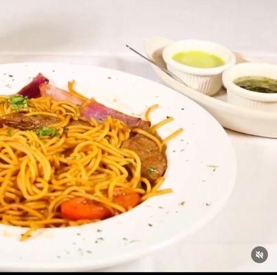 Tallarin Saltado de Carne. Strips of filet mignon sautéed with red onions, tomatoes, soy sauce, vinegar, cilantro, and spaghetti.