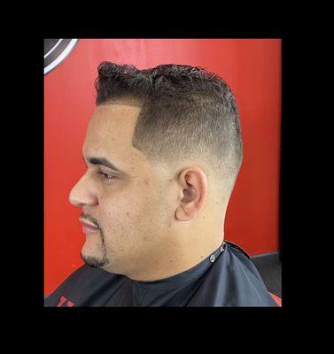 Mid bald fade and scissor cut on top w/ razor goatee line up.