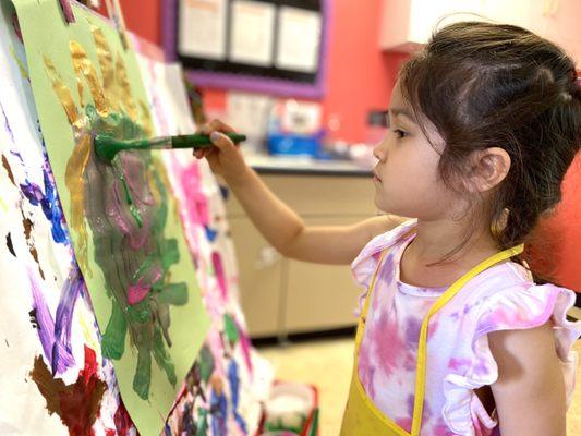 Practicing self-expression through an art activity at individual easels.