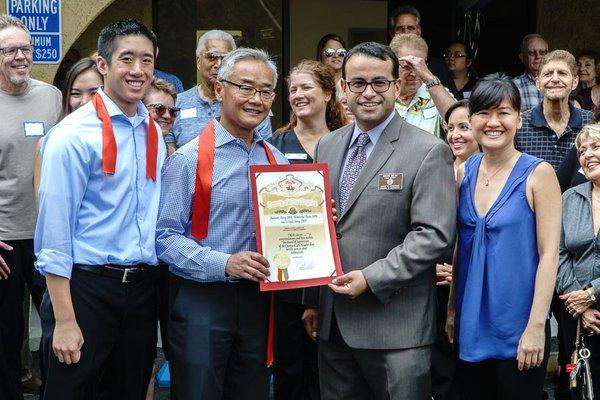 Dr. Craig Jeong, Dr. Bennett Jeong and Dr. Kimberly Foon accepting a signed congratulations from Mike Antonovich.