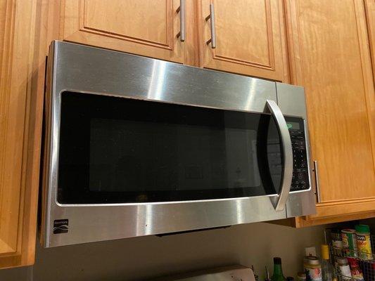 Microwave does not heat when running, nor does the stove light below, and needs replacement.