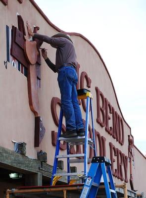 Texas muralist Stylle Reed puts the finishing touches on the Big Bend Saddlery store front.