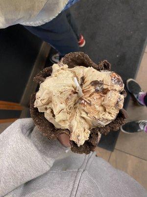 Coffee ice cream with fudge in a chocolate waffle cone