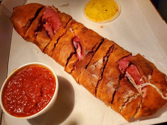 large Stromboli with ham salami banana peppers and black olives and marinara dipping sauce