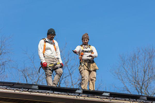 Exact Solar installers working safely on the roof, planning a new installation for a barn.