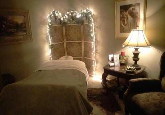 Soothing massage therapy room with soft lighting, relaxing music and the trickling sounds of a water fountain.