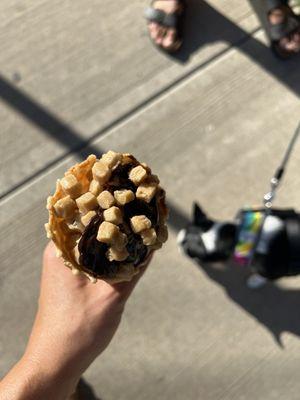 Vanilla soft serve on waffle cone topped with hot fudge and cookie dough