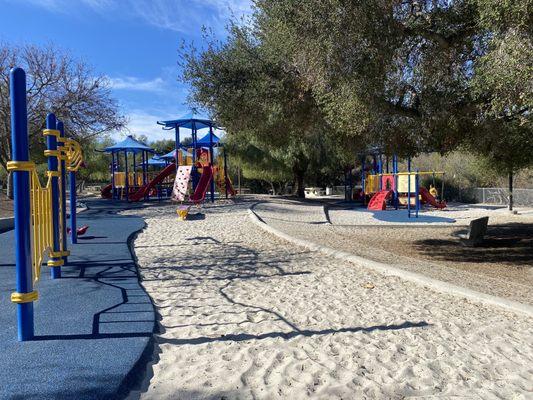 View from swingsets- left in photo is balancing/climbing area,center large and right small structures