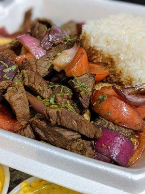 Lomo Saltado ($15.99) - Peruvian-style beef stir-fry mixed with onions, tomatoes, cilantro, soy sauce, and served on fries and jasmine rice.