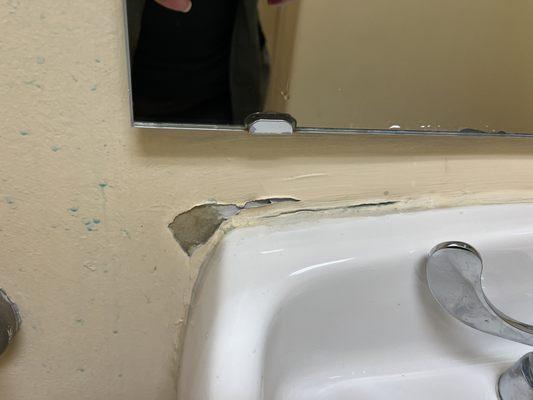 Peeling paint and cracked sink in the patient bathroom.