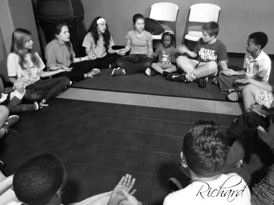 The kids from our goup and the resident kids sit in a circle in the gym socializing and playing games