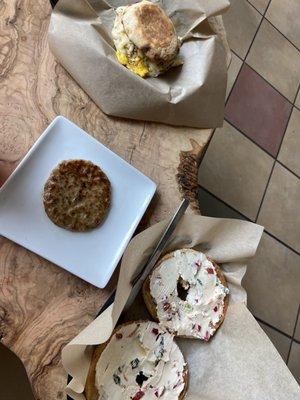 Bagel with veggie cream cheese and sausage and breakfast sandwich