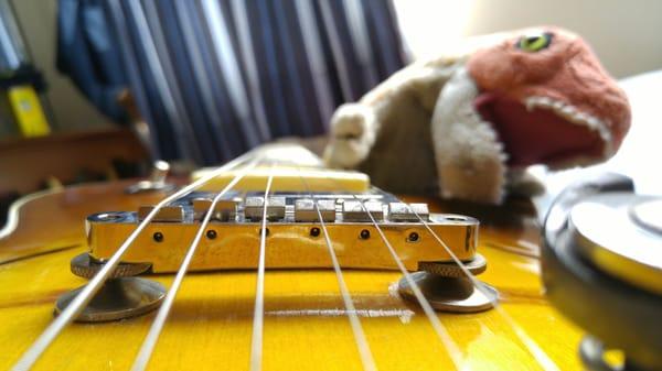 Bridge saddles properly slotted, strings now follow fretboard radius.