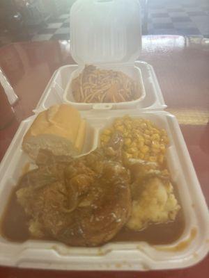 Smothered pork chops, mashed potatoes, corn, French bread, baked spaghetti.