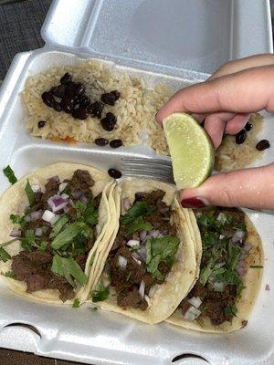 Steak tacos with rice and beans.