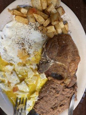 Pork Chop, eggs refried beans and potato plate.