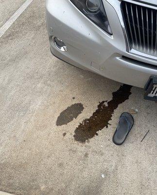 Oil slick forming just after parking, flip flop for scale.