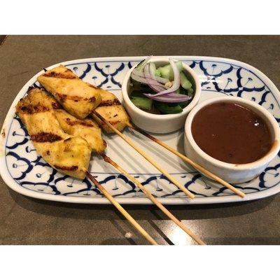 Chicken satay with pickled cucumber salad and peanut sauce on the side.