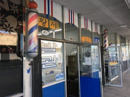 Exterior of barber shop. Easy to spot barber poles.