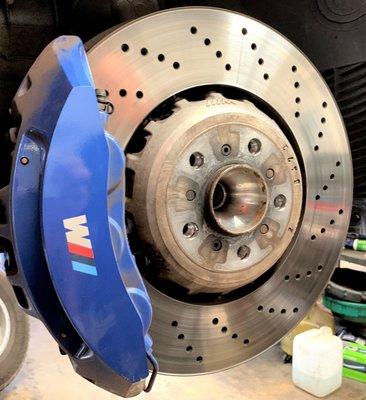 A stunning cross-drilled brake rotor and caliper for a BMW M6