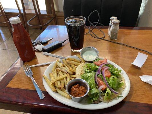 Shawarma sandwich with fries and two sauces.