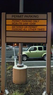 Sign in the lot that implies you have to pay on weekends, but other sign at building says weekends are free (and they apparently are)