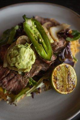 Carne Asada Chef Specialty: Enjoy tender steak, rice, grilled onions, guacamole, jalapeño, and tortillas for a savory, flavorful dish.