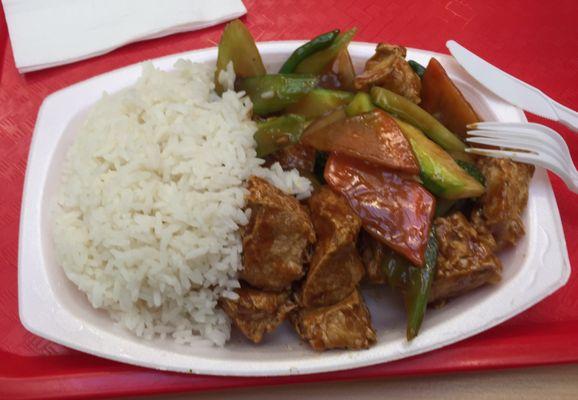 Tofu in brown sauce with veggies and white rice.