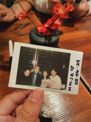 The server takes Polaroids of everyone.