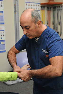 Dr Larry Holt adjusting a patient hand.